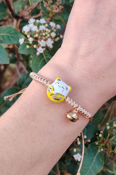 bracelet chat maneki neko en porcelaine jaune, porté au poignet