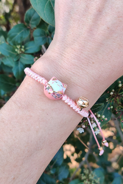 bracelet chat maneki neko en porcelaine rose, porté au poignet